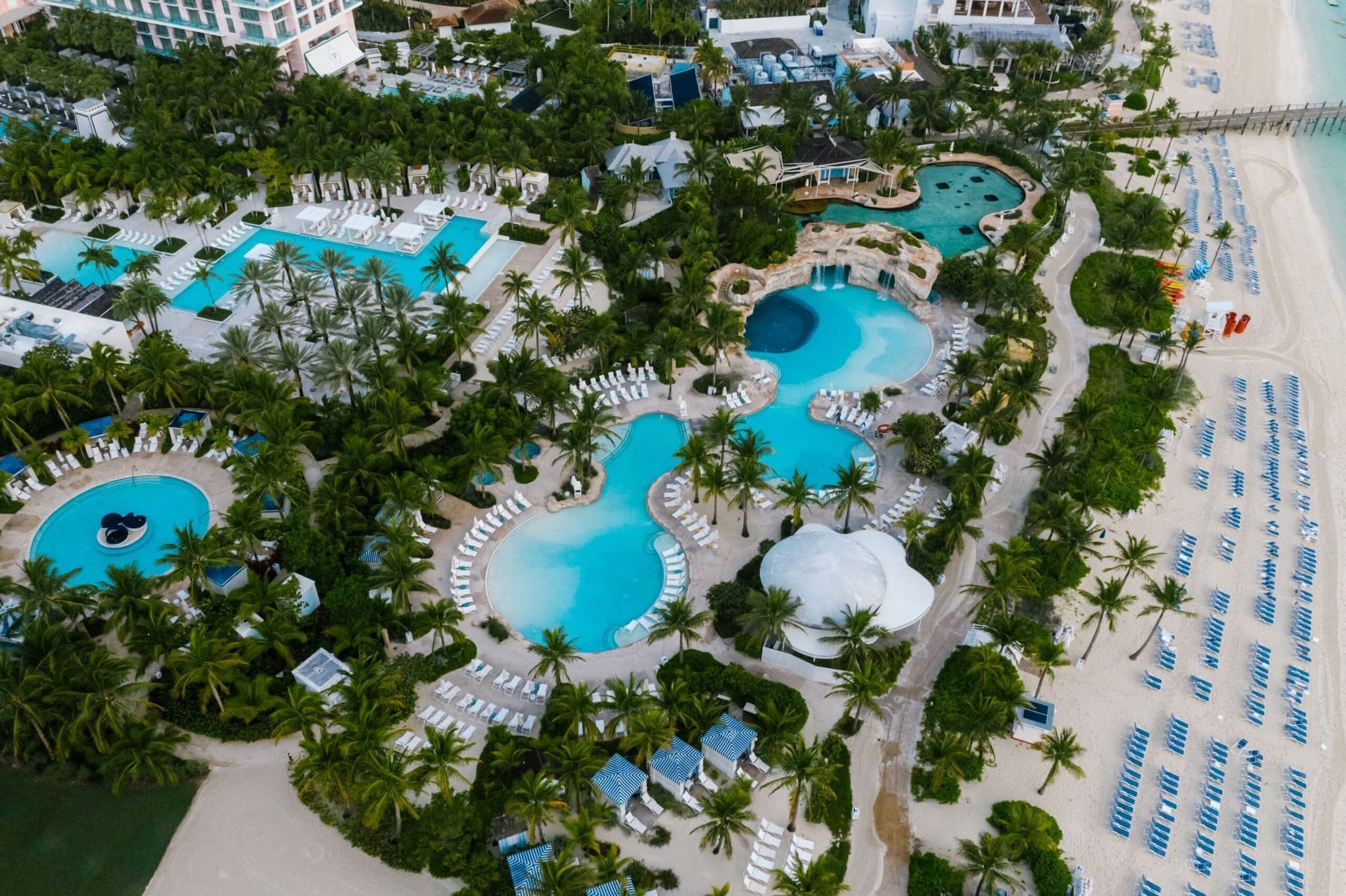 Aerial view of a resort pool complex beside the sea, representing a multi-property hospitality group