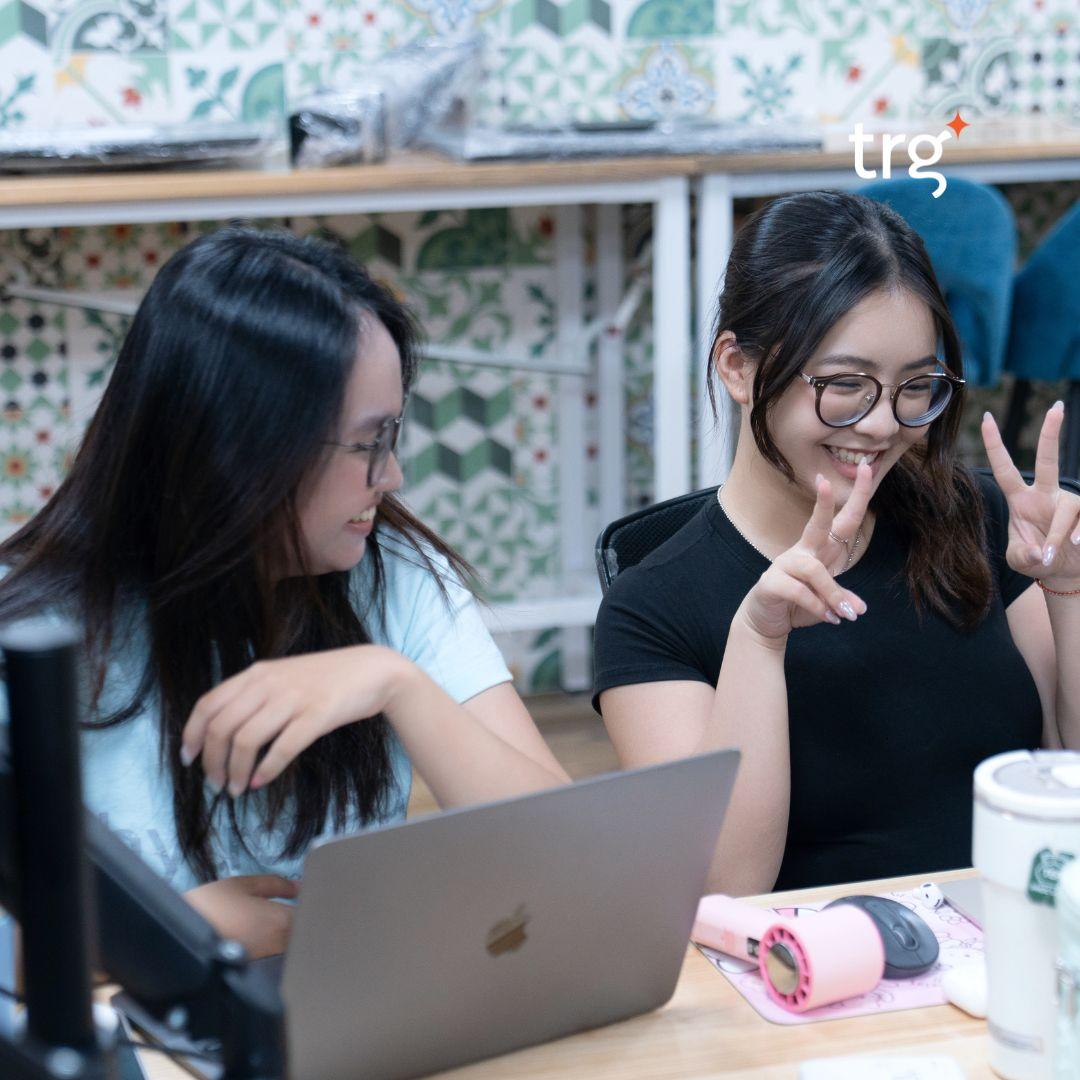Two TRG interns working together at a laptop